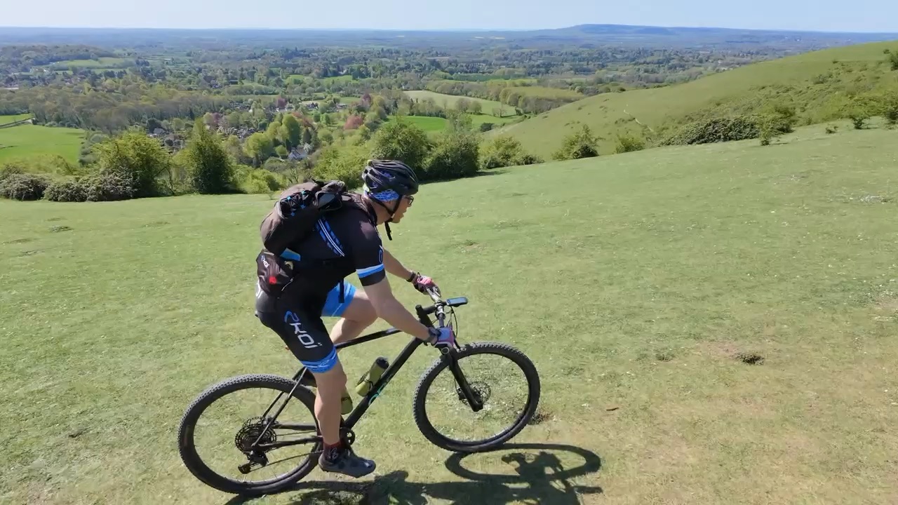 Drone view of Richard riding across the open hills at Gatton Park