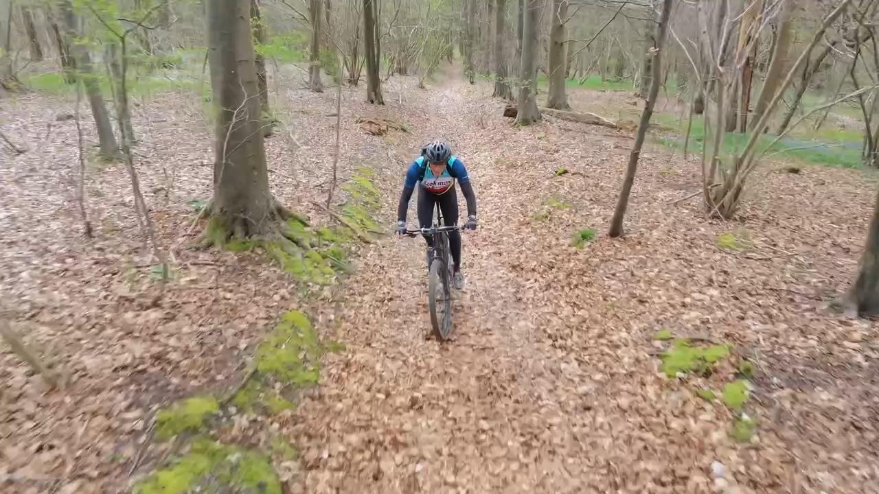 Drone view of Richard riding through Ranmore woodland